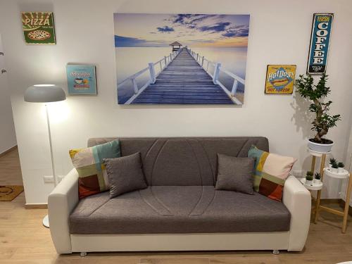 a couch in a living room with a painting of a pier at Villa Manto Bed and Breakfast - Torre Annunziata Pompei in Torre Annunziata
