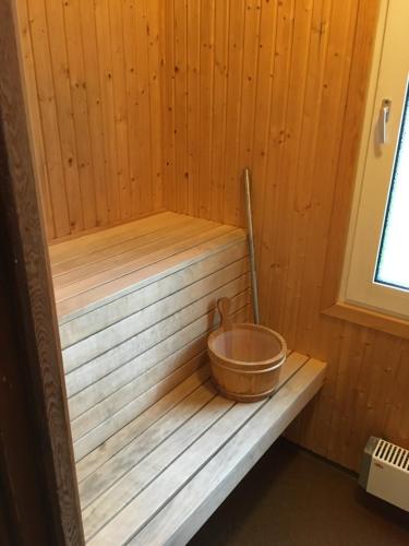 a wooden sauna with a bowl sitting on a bench at House in the heart of Lapland P4 in Puoltikasvaara