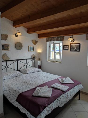 a bedroom with a large bed with towels on it at Apartment Valun 60 in Valun