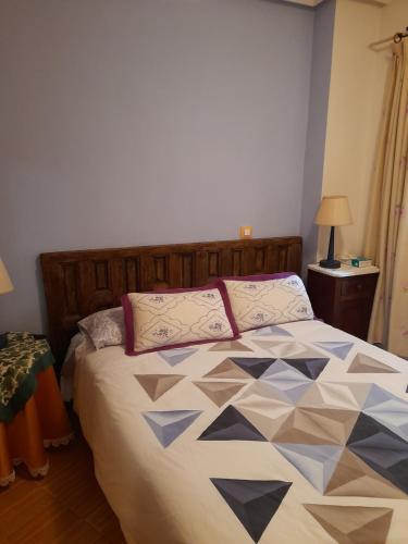 a bedroom with a bed with a quilt on it at CAMINO A MONASTERIO in Alhama de Aragón