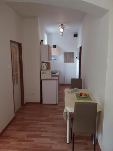 a small room with a table and chairs and a kitchen at Kapitula centrum in Banská Bystrica
