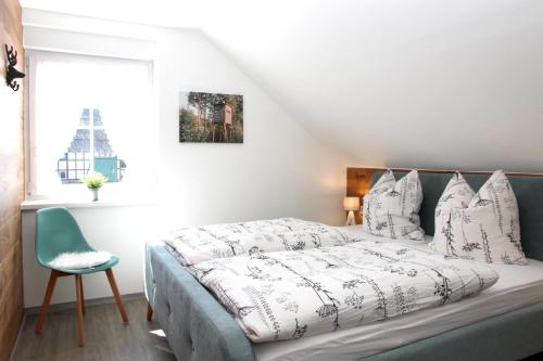 a bedroom with a bed and a chair and a window at Xavers Ranch in Meschede