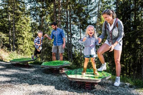 a woman and two children playing on surfboards at Der Schütthof in Zell am See