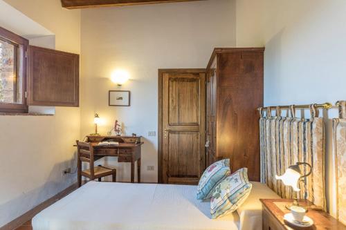 a bedroom with a bed and a desk and a table at Casa vacanze San Giusto in Sovicille