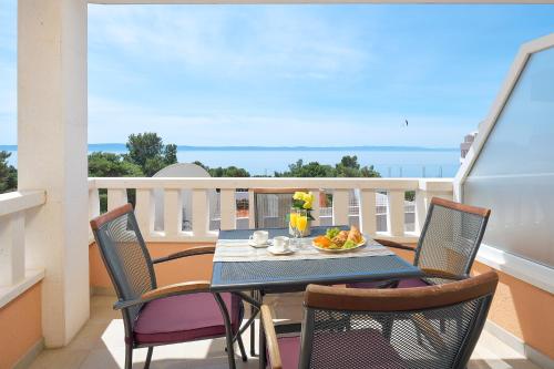 a balcony with a table with a bowl of fruit on it at Villa Ivano in Makarska