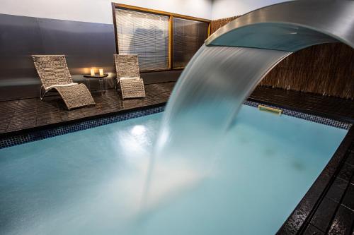 una piscina con cascada en un hotel en LA CASONA Encanto Rural - ApartaHotel SPA Llanes, en Llanes