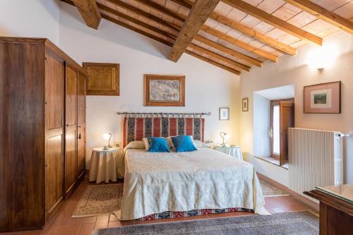 a bedroom with a large bed with blue pillows at Casa vacanze San Giusto in Sovicille