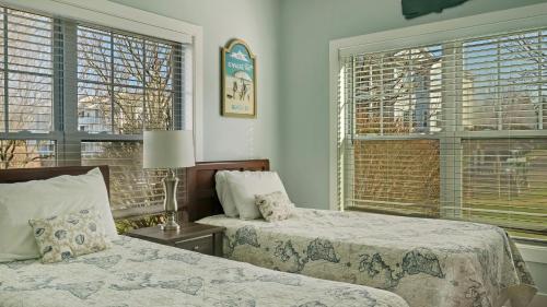 a bedroom with two beds and two windows at The Cliffside Resort Condominiums in Greenport