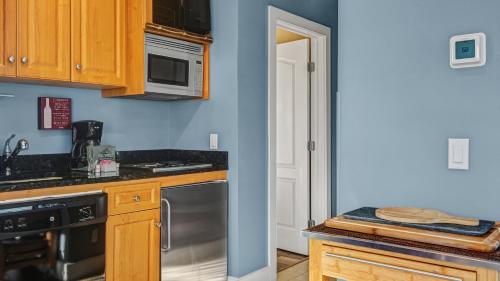 a kitchen with wooden cabinets and a stainless steel dishwasher at The Cliffside Resort Condominiums in Greenport