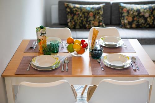 a table with plates and bowls of fruit on it at Malinska -Krk in Malinska