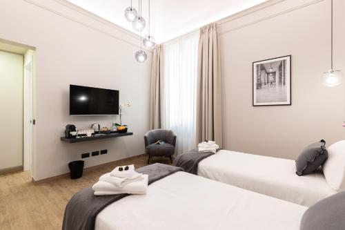 Posteľ alebo postele v izbe v ubytovaní Foresteria di Piazza Cavour - Luxury Suites & Guest House