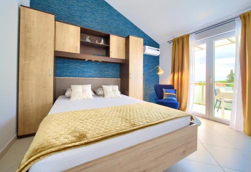 a bedroom with a large bed and a blue wall at Malinska -Krk in Malinska