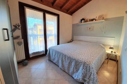 a bedroom with a bed and a large window at IL TORCHIO rooftop apartment with wide terrace in Sirmione