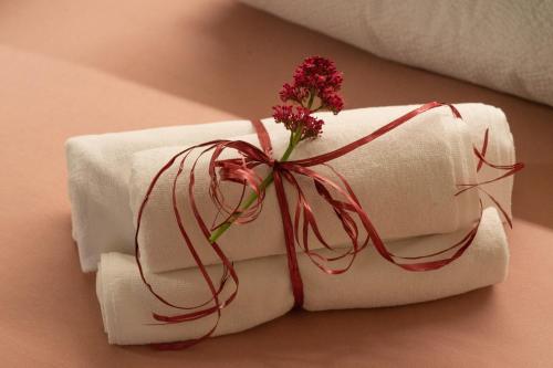 a stack of white towels with a flower on top at L' aurora in Pieve Tesino