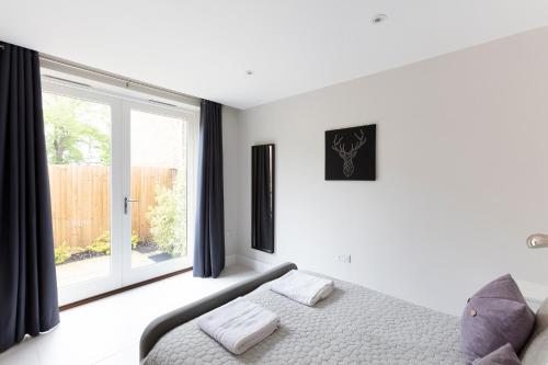 a bedroom with a bed and a large window at Immaculate Central Windsor Town House with parking in Windsor