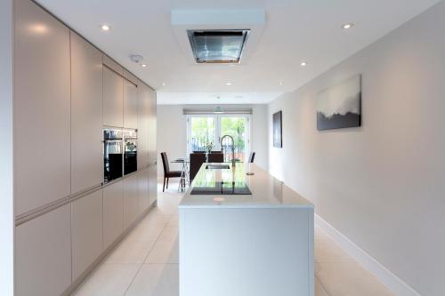 a kitchen and dining room with a glass table at Immaculate Central Windsor Town House with parking in Windsor