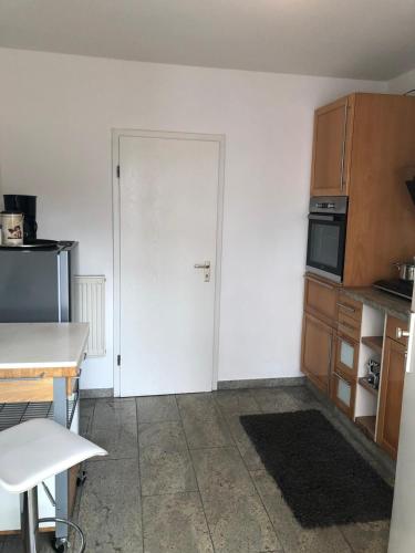 a kitchen with a white door and a kitchen with a table at Kranenbruch in Schwalmtal