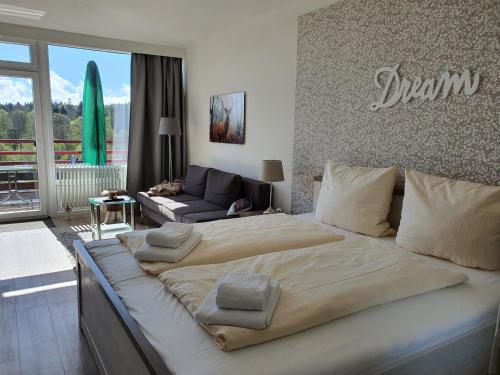 ハーネンクレー・ボックスヴィーゼにあるHarz Dream - Vier Jahreszeitenのベッドルーム(大型ベッド1台付)、リビングルームが備わります。