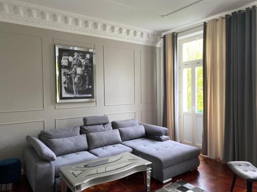 a living room with a blue couch and a window at Apartment Anglicka 138 in Mariánské Lázně