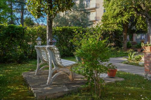 サン・ジミニャーノにあるLa Casa di Agnese - Appartamenti a San Gimignanoの灯台付き庭園に座る白いベンチ