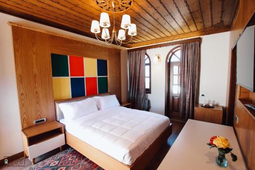 a bedroom with a bed and a table at KERCULLA Resort in Gjirokastër