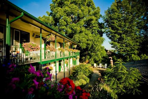 ein Haus mit einem Balkon mit Blumen darauf in der Unterkunft The Gananoque Inn & Spa in Gananoque