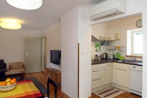 a kitchen and a living room with a table at Spacious Piran Central Apartment for 5 Pax BG in Piran