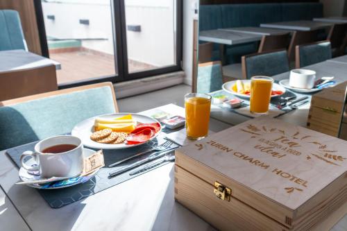 a table with a tray of breakfast food and a box with a happy anniversary sign at Zurin Charm Hotel in Lisbon