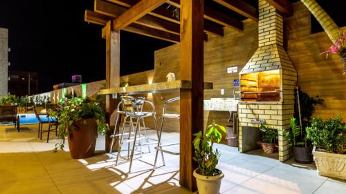 a patio with a bar with chairs and plants at Hotel & Pousada Favareto in Florianópolis