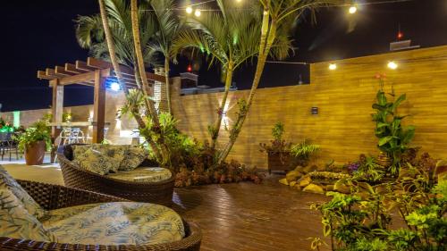 a patio with chairs and palm trees at night at Hotel & Pousada Favareto in Florianópolis