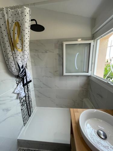 une salle de bain avec un lavabo et une fenêtre dans l'établissement Villa Lauriers roses - Clim Wifi parking - Piscine dans résidence - MARINA ST CYPRIEN, à Saint-Cyprien