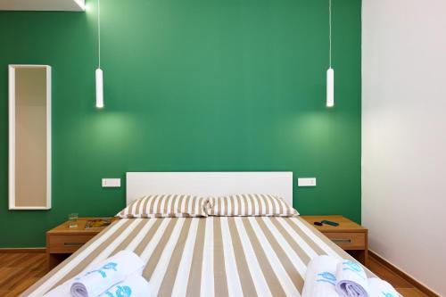 ein Schlafzimmer mit einem Bett und grünen Wänden in der Unterkunft ZEROPENSIERI B&B in Agropoli