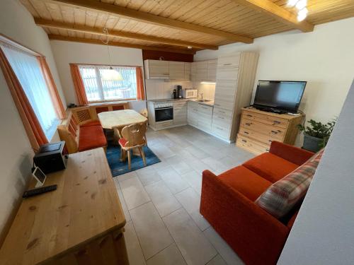 a living room with a couch and a table and a tv at Apartment Fadail 2B in Lenzerheide