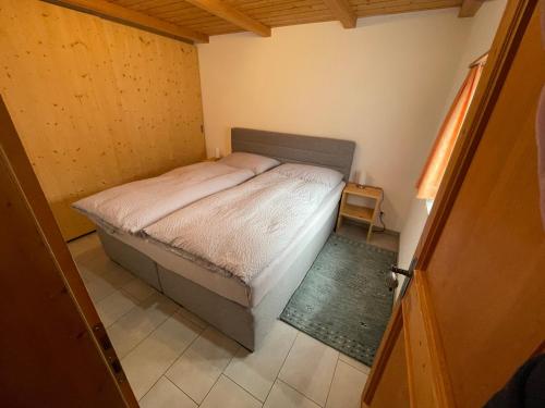 ein kleines Schlafzimmer mit einem Bett in einem Zimmer in der Unterkunft Apartment Fadail 2B in Lenzerheide