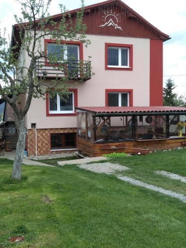 a house with a porch and a tree in front of it at Vysoké Tatry Gerlaška in Gerlachov