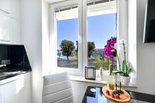 a kitchen with a window and a table with flowers at Lauris Luxury Apartment Zadar in Zadar