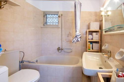 łazienka z wanną, toaletą i umywalką w obiekcie Koko's summer house w mieście Nea Makri