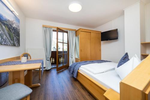 une chambre d'hôtel avec un lit et un bureau dans l'établissement Michis Aparthotel, à Flachau