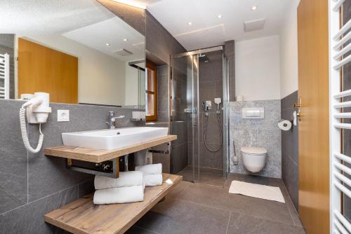 un baño con lavabo y ducha en Michis Aparthotel, en Flachau