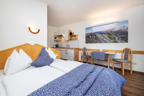 Una habitación de hotel con una cama y una cocina. en Michis Aparthotel, en Flachau