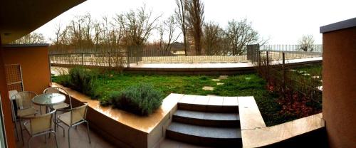 a patio with a garden with a table and chairs at Club 218 Wellness Luxus Apartman in Siófok