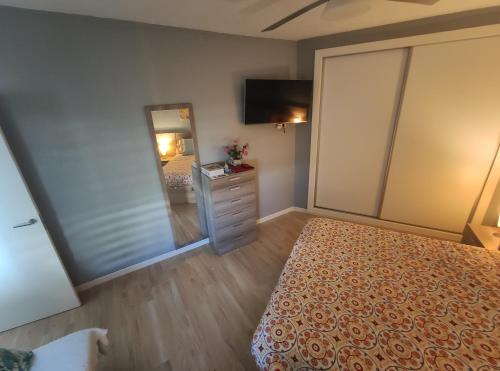 a bedroom with a bed and a dresser and a mirror at APARTAMENTO EN BENALBEACH in Benalmádena