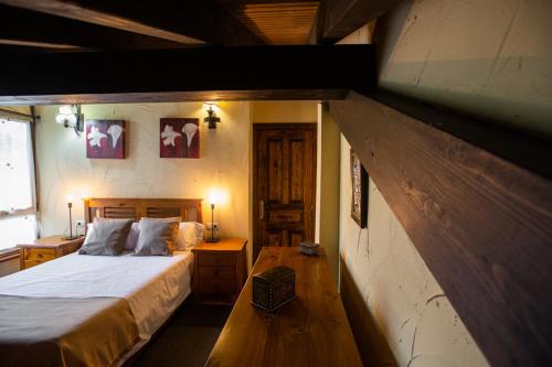 ein Schlafzimmer mit einem großen Bett in einem Haus in der Unterkunft Apartamentos el Caserón in Soto de Cangas