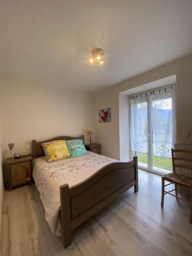 une chambre avec un grand lit et une fenêtre dans l'établissement La voûte, à Le Noyer