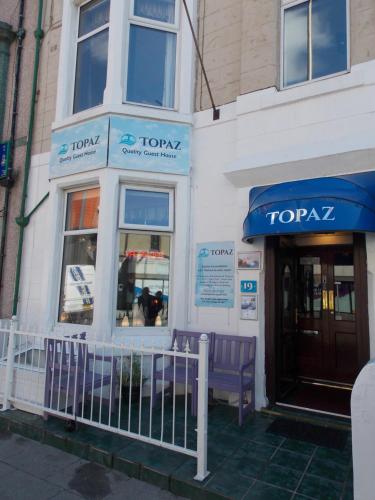 a toza store with a purple bench outside of it at Topaz Blackpool in Blackpool