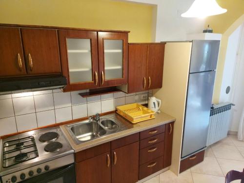 kuchnia z drewnianymi szafkami i lodówką ze stali nierdzewnej w obiekcie P&Z Apartments w Rabie