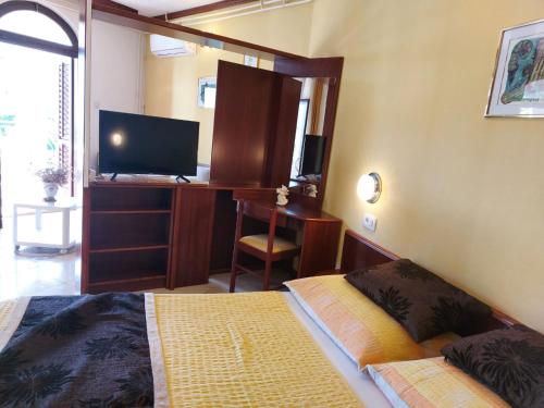 sypialnia z łóżkiem i biurkiem z telewizorem w obiekcie P&Z Apartments w Rabie