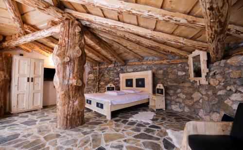 a bedroom with a bed in a stone wall at Odai din Plai in Moieciu de Sus