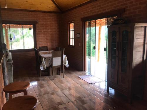 a dining room with a table and a table and chairs at Ibitiaçu Chales in Conceição da Ibitipoca