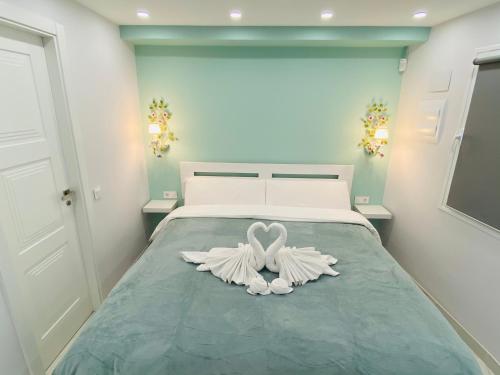 Un dormitorio con una cama con dos cisnes blancos. en Studio-near the beach, BBQ and seawater pool, en Marbella